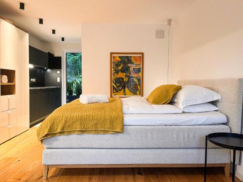 a bedroom with a bed with a yellow blanket on it at Garden Apartment Untermühle in Bressanone