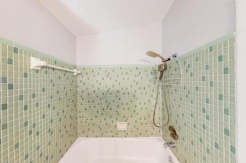 baño con ducha de azulejos verdes en Dolphin Court #5, en St Pete Beach