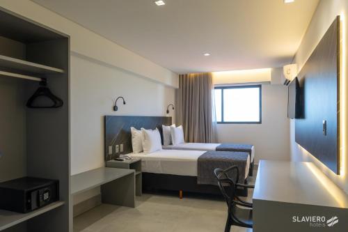 a hotel room with a bed and a desk at Slaviero João Pessoa in João Pessoa