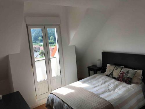 ein weißes Schlafzimmer mit einem Bett und einem Fenster in der Unterkunft Precioso Ático con parking privado. Vistas al Río in Limpias