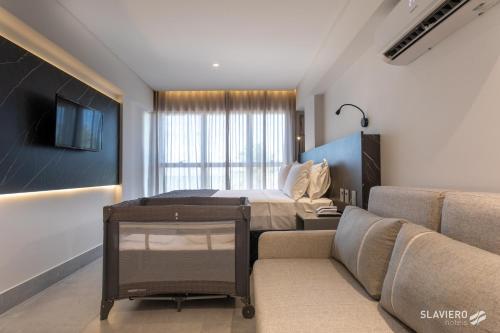 a living room with a bed and a couch at Slaviero João Pessoa in João Pessoa
