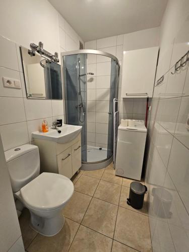 a bathroom with a toilet and a shower and a sink at Szczecin Centrum 4 in Szczecin