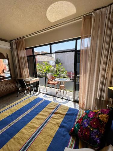 a bedroom with a bed and a view of a patio at Casa de las Palmas Guest House in Oaxaca City