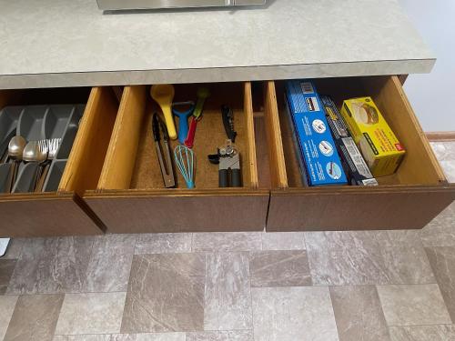 a drawer under a counter filled with books and utensils at One Bedroom Main floor Apartment in Camrose