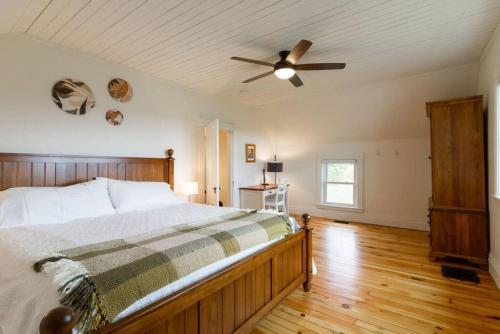 Un dormitorio con una cama y un ventilador de techo. en Waterfront with Hot Tub Joanie's Farmhouse, en Bath
