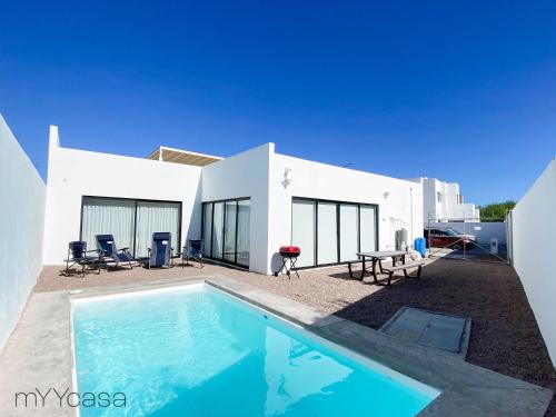 a swimming pool in front of a white house at House with Pool in Sector Bahia, Close to the Beach - Casa Amalia in San Carlos