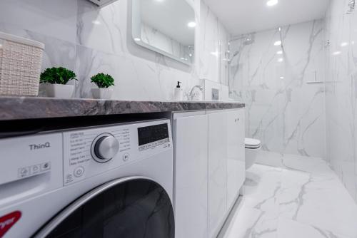 a white laundry room with a washer and dryer at PALANGA DAUKANTO APARTAMENTAI in Palanga