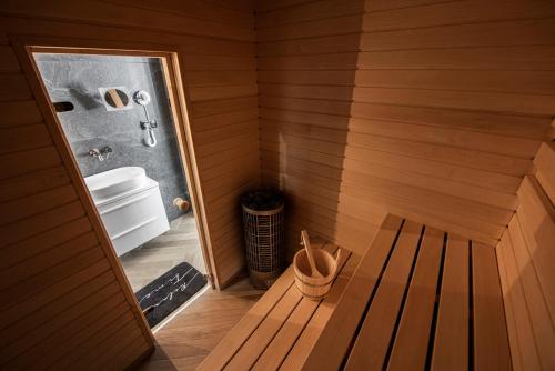 a sauna with a tub and a bench in it at Lazur Apartamenty Domki in Sarbinowo