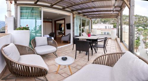 a patio with chairs and a table on a balcony at Los Geranios in Port de Soller