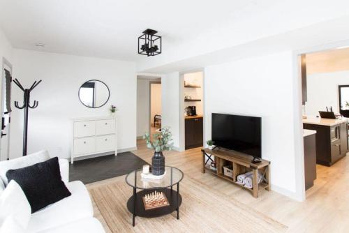 een witte woonkamer met een witte bank en een tv bij Walk to Downtown Picton, 4-bedroom in Picton