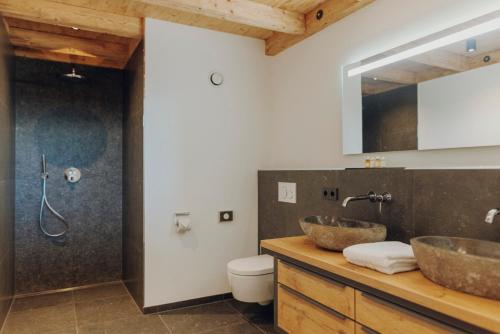 un bagno con due lavandini su un bancone in legno di Platzhirsch Ofterschwang a Ofterschwang