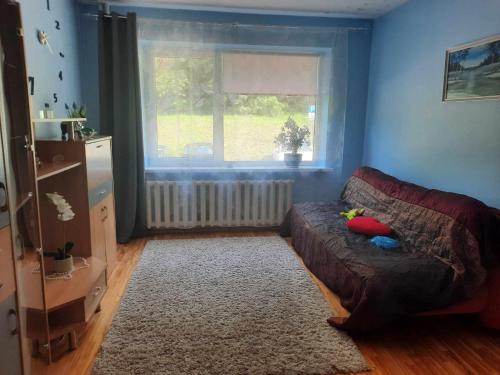a living room with a couch and a window at Green Vilnius Getaway in Vilnius