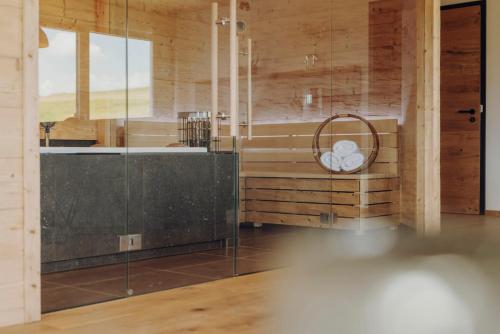 a bathroom with a glass shower and a sink at Platzhirsch Ofterschwang in Ofterschwang