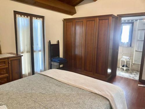 een slaapkamer met een bed en een grote houten kast bij Appartamento Santamarcellina in San Giorgio