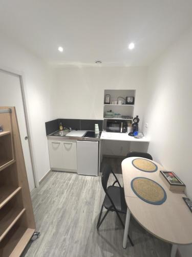 - une petite cuisine avec une table et un comptoir dans l'établissement Au domaine des roches, à Saint-Pierre-sur-Dives