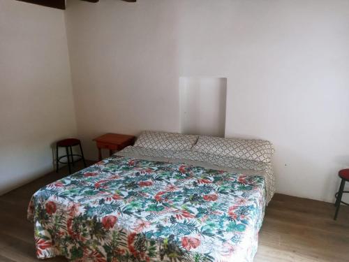 a bedroom with a bed with a floral bedspread at Chozos Cottage by VV Canary Ocean Homes in Las Cruces