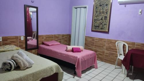 a room with two beds and a mirror at Pousada Carimbó in Fortaleza