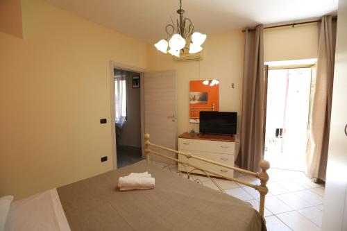 a bedroom with a bed and a tv and a window at La casa di Bella in Lamezia Terme