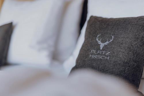 a pillow on a bed with a dark trooper insignia on it at Platzhirsch Ofterschwang in Ofterschwang