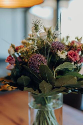 a vase filled with a bouquet of flowers on a table at Platzhirsch Ofterschwang in Ofterschwang