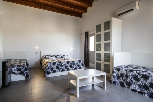 a room with two beds and a table at Opera Suite in Castellammare del Golfo