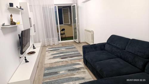 a living room with a couch and a television at Natural House in Constanţa
