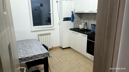 uma pequena cozinha com uma mesa e um frigorífico branco em Natural House em Constança