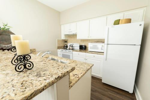 a kitchen with white cabinets and a white refrigerator at King's Creek Resort by Endless Resorts in Williamsburg