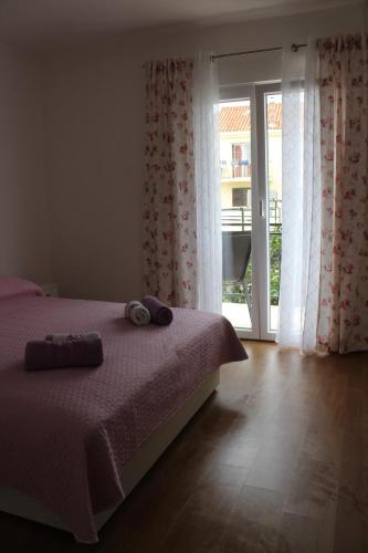 1 dormitorio con 1 cama y puerta corredera de cristal en Apartments Ivan & Ana, en Korčula