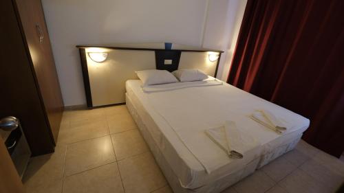 ein Schlafzimmer mit einem Bett mit zwei Servietten darauf in der Unterkunft AGORA APART OTEL ALANYA in Alanya