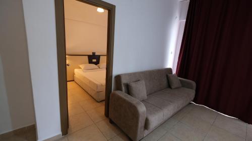 a living room with a chair and a mirror at AGORA APART OTEL ALANYA in Alanya