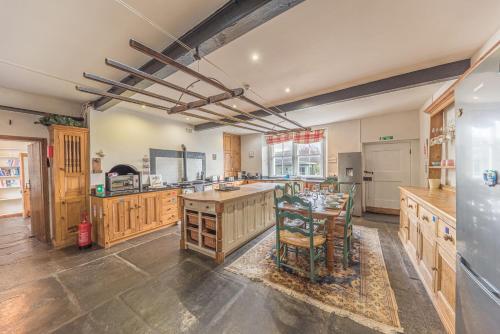 a large kitchen with wooden cabinets and a table at Abbey Farm House in St Bees