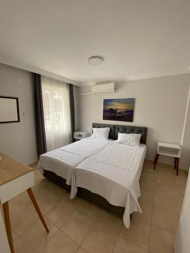 a bedroom with a large bed with white sheets at FA&BER Homes in Marmaris