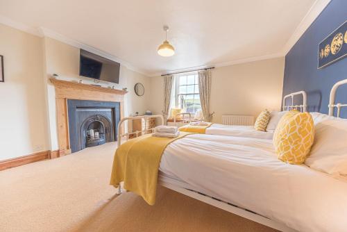 a bedroom with two beds and a fireplace at Abbey Farm House in St Bees