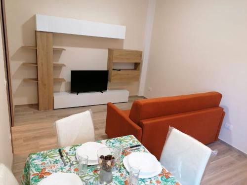 een woonkamer met 2 tafels en een televisie bij Perla Marina - Monna Sonia in Agropoli