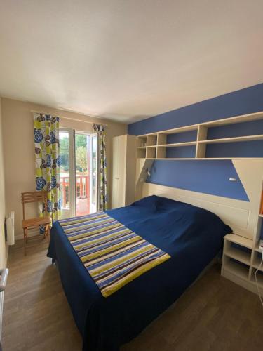 - une chambre avec un lit bleu et une tête de lit bleue dans l'établissement Maison à Lacanau Océan classée 2 étoiles, à Lacanau-Océan