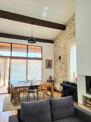 トレイユにあるsplendide maison catalane renovee avec grande terrasse et garageのリビングルーム(テーブル、椅子、ピアノ付)
