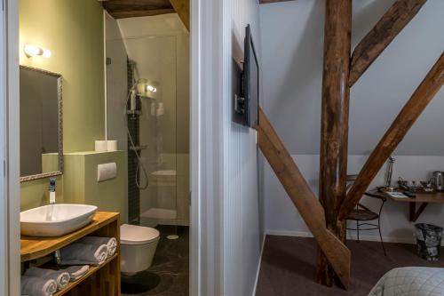 een badkamer met een wastafel en een douche bij Hotel B&B Hoeve de Vredenhof in Zuidlaren