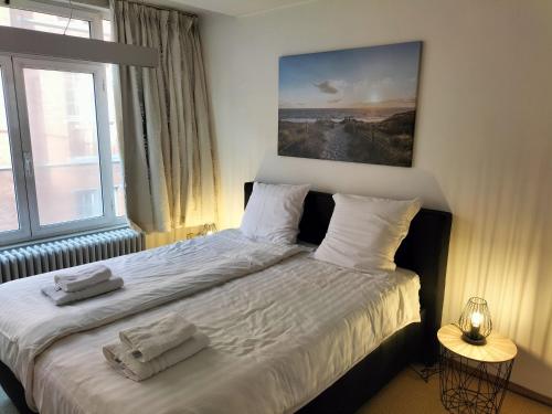 um quarto com uma cama com duas toalhas em bel etage woning em Gent