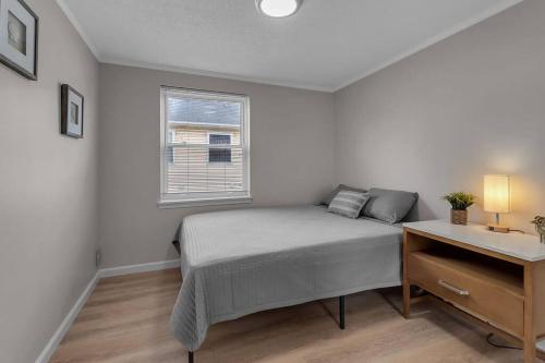 a bedroom with a bed and a desk and a window at Modern Trendy Downtown in Buffalo