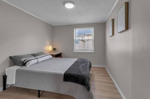 a white bedroom with a bed and a window at Modern Trendy Downtown in Buffalo