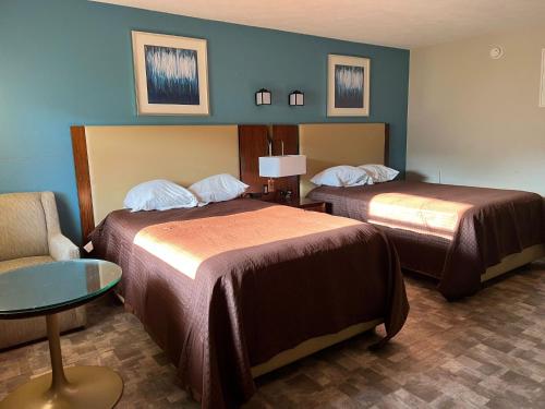 a hotel room with two beds and a chair at The Boston Inn in Westminster