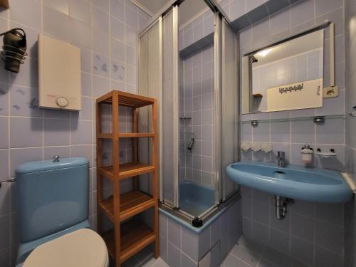 ein Badezimmer mit einem blauen WC und einem Waschbecken in der Unterkunft Probsteiblick in Wendtorf