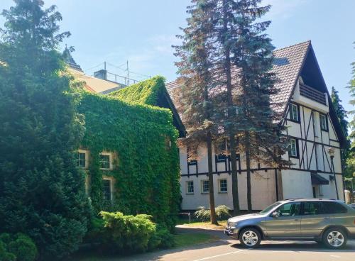 a car parked in front of a house with ivy at Great Polonia Beach & Molo in Puck