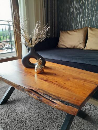 a wooden coffee table with a vase on top of it at Vrnjačka Promenada - Pešačka zona - Baby friendly in Vrnjačka Banja