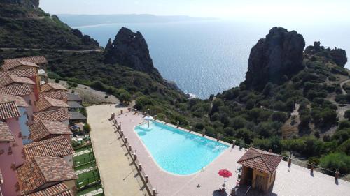 a view of a swimming pool with the ocean in the background at L'Emozione Tanca Piras in Nebida