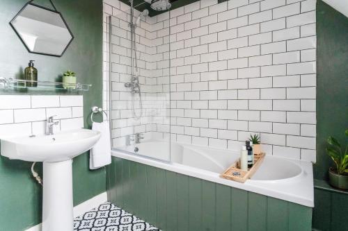 a bathroom with a tub and a sink at Redesdale view with private garden in Moreton in Marsh