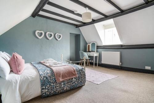 a bedroom with a large bed and a desk at Redesdale view with private garden in Moreton in Marsh