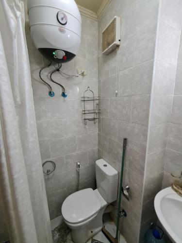 a bathroom with a toilet and a blow dryer on the wall at ستوديو جولف بورتو مارينا in El Alamein