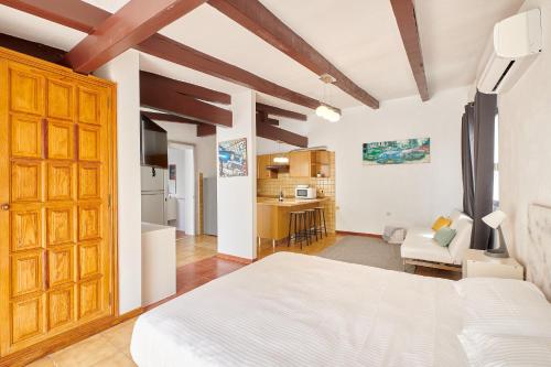 una camera da letto con un letto bianco e una cucina di BeExclusive apartamentos ad Adeje
